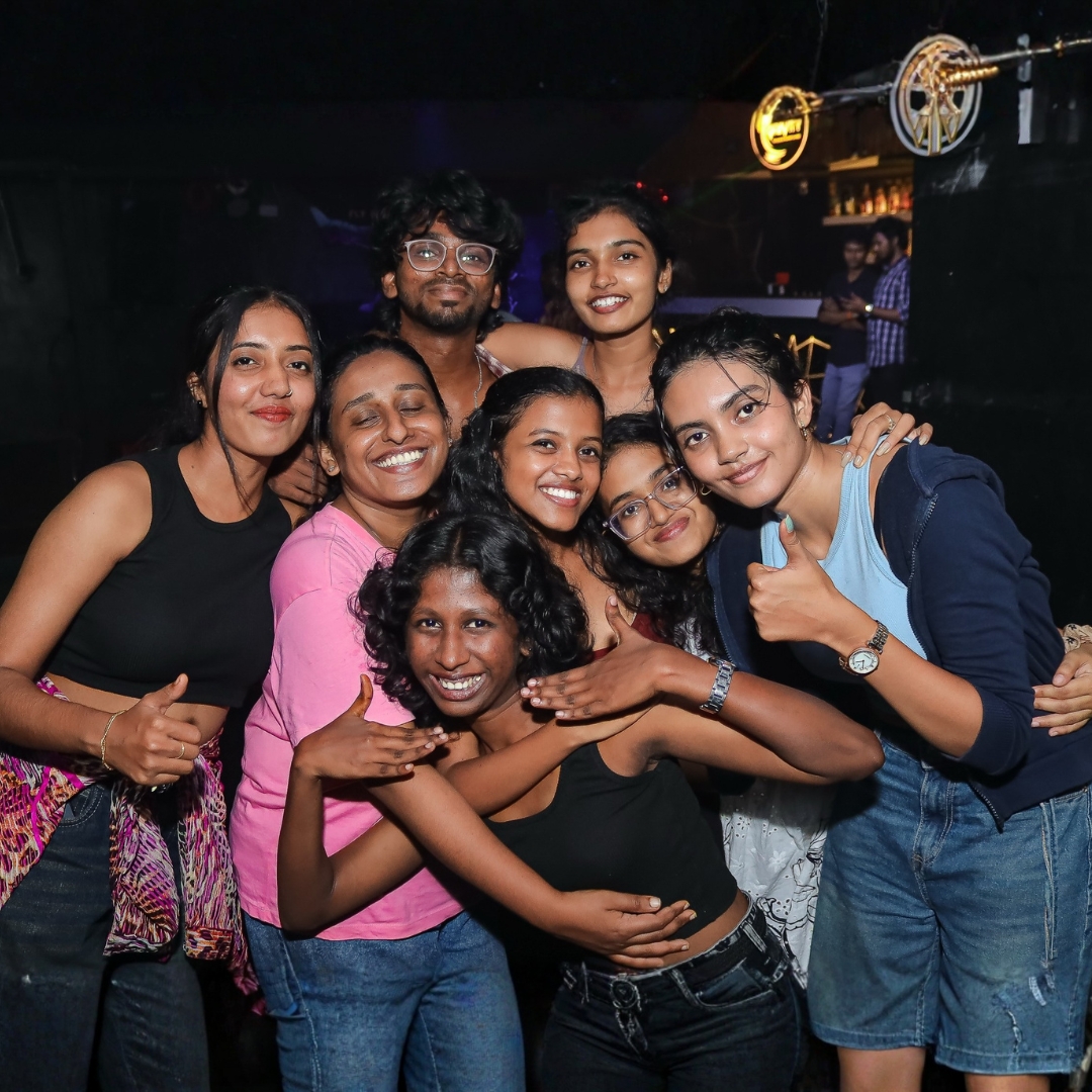Group of friends posing together with big smiles on the floor at Gravity